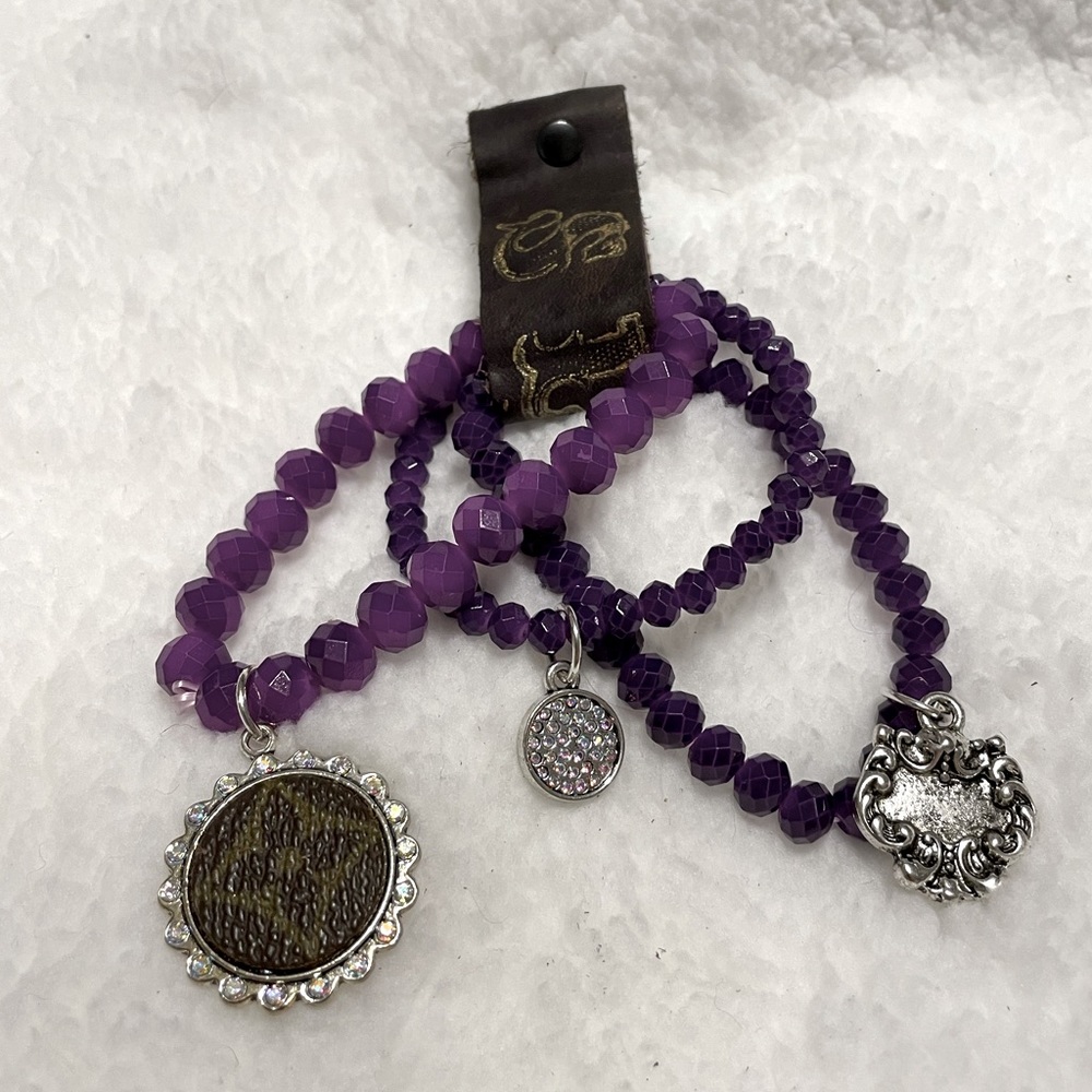 Beautiful purple stretch bracelet with silver charms. Never worn.